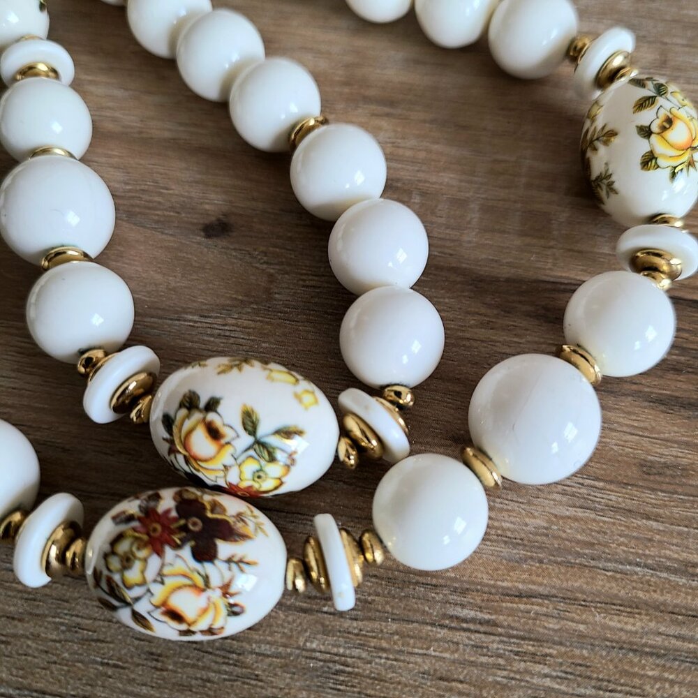 Vintage necklace with large cream color plastic round beads and floral design.